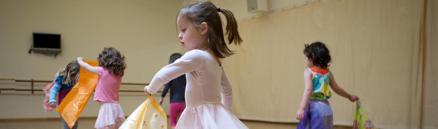 An image of young children playing and dancing with fabric