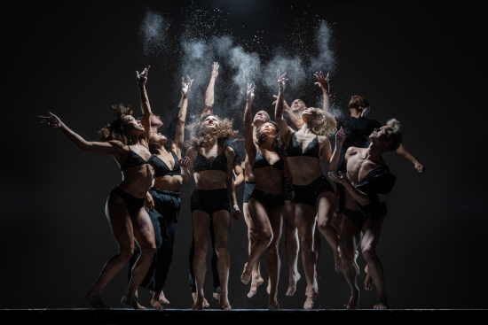 ODC/Dance Company Dancers Dancers on dark stage jumping with white chalk in the air